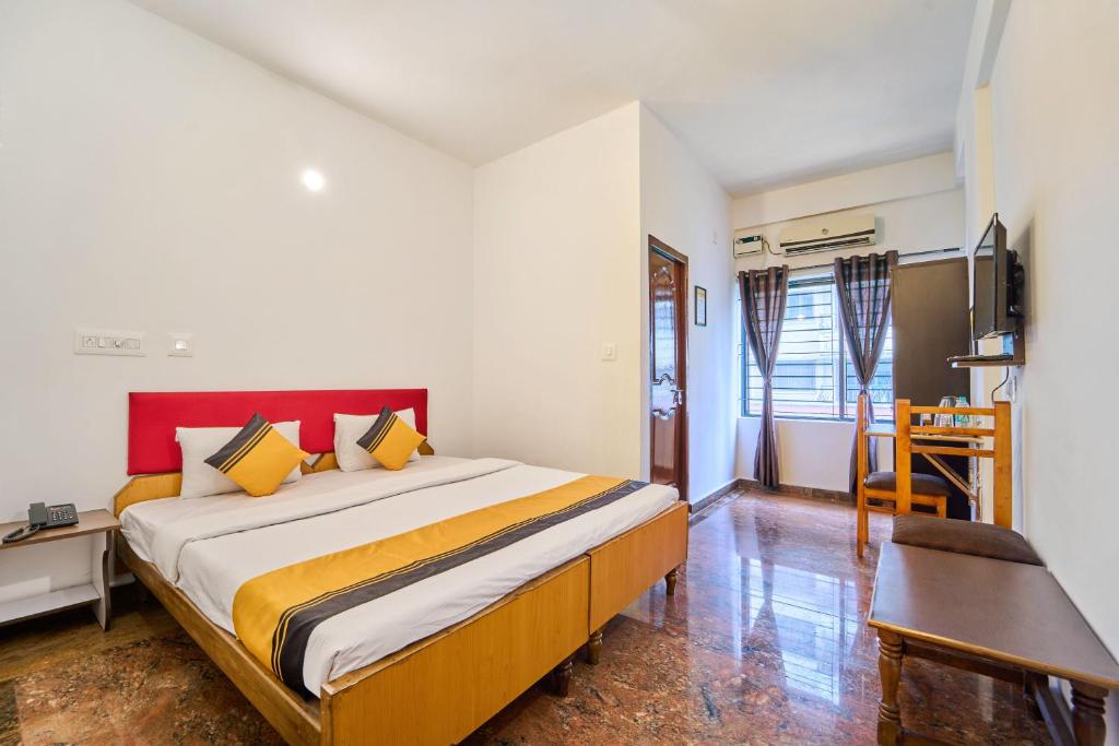 a bedroom with a large bed and a desk at Itsy Hotels R S Bhavan, 2 Km From MIT Gate in Manipal