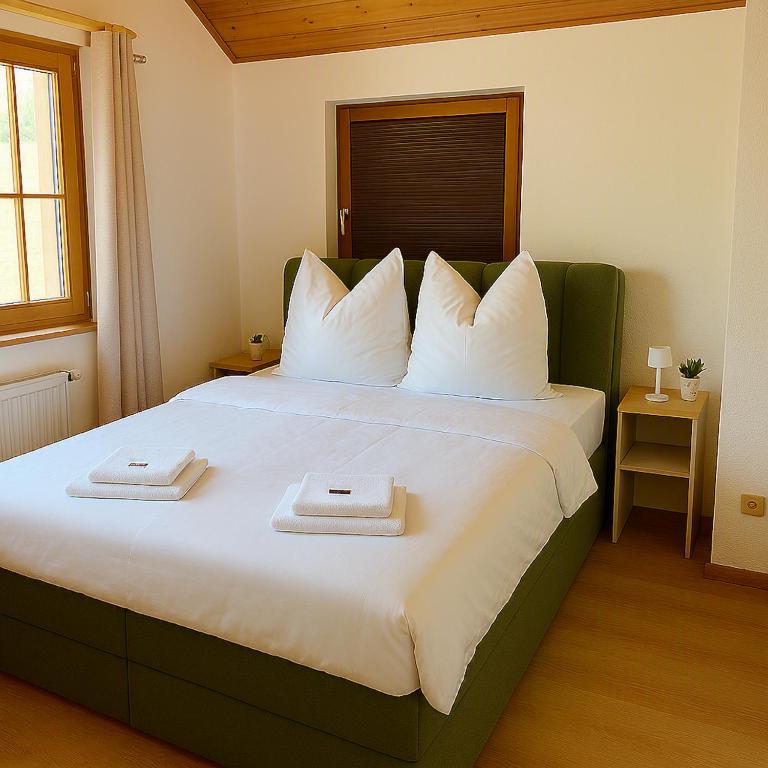 a bedroom with a large bed with two towels on it at Direkt am Wanderweg, Ferienwohnung im Allgäu nahe Oberstaufen in Oberstaufen