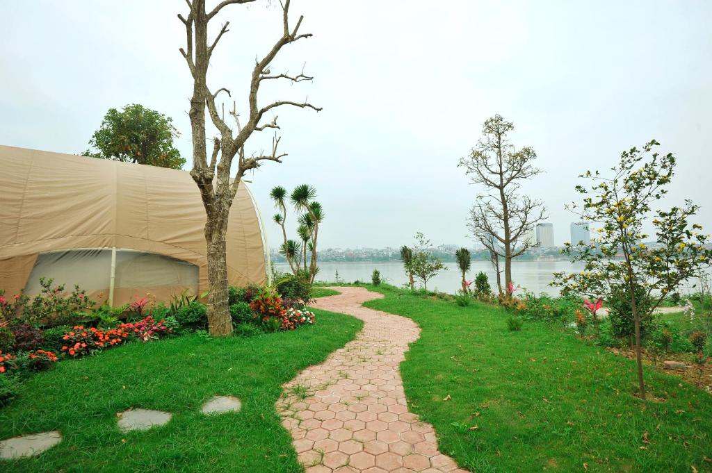 a tent on the grass next to a walkway at NSH Riverside Glamping Resort in Hanoi