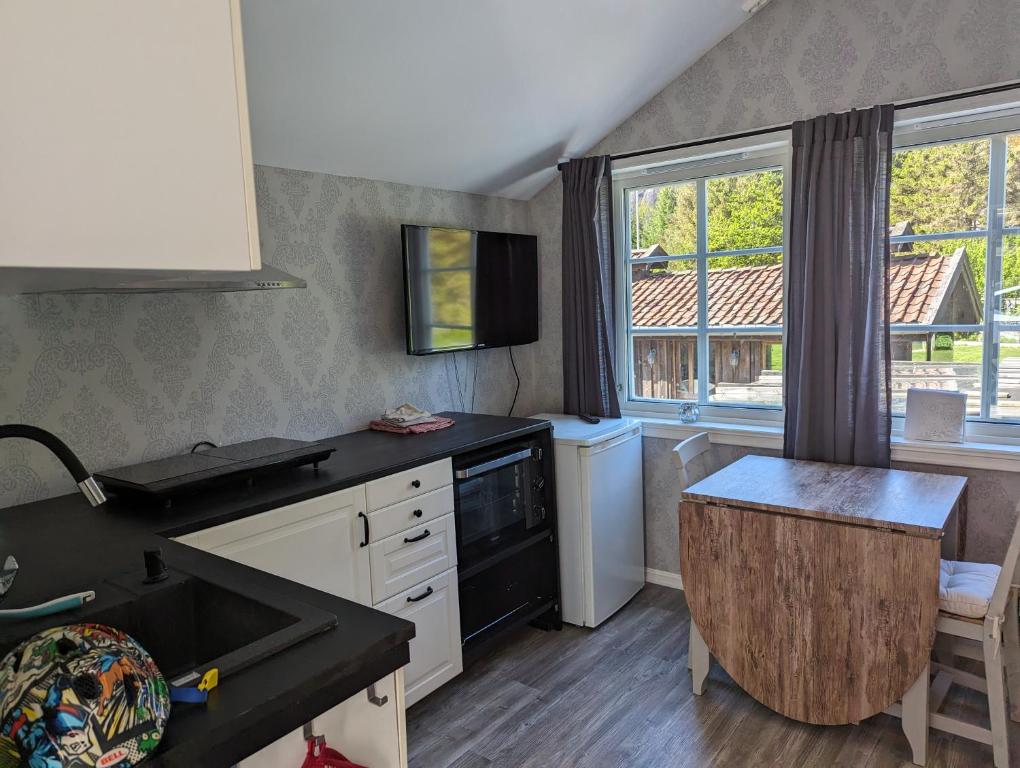 a kitchen with a sink and a stove at Cozy Fjord Studio in Åna-Sira Near Brufjell and Jøssingfjord in Flekkefjord