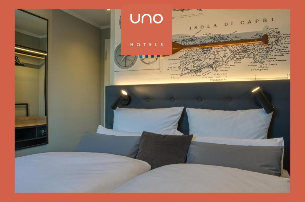 a hotel room with two beds and a map on the wall at UNO Hotel Hamburg Central 053 in Hamburg