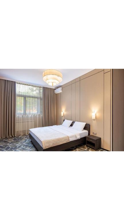a bedroom with a large bed and a large window at Rush Inn Hotel in Astana