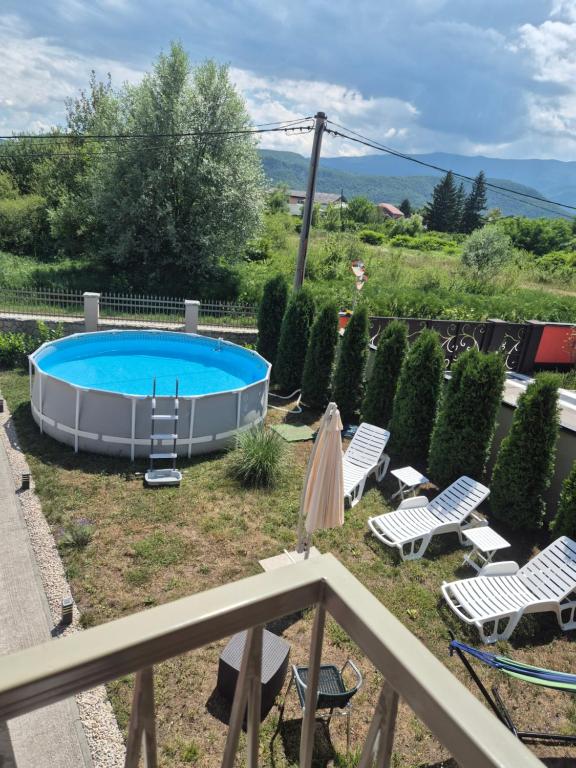 a swimming pool in a yard with lounge chairs and avisorvisor at Apartman IN in Bihać