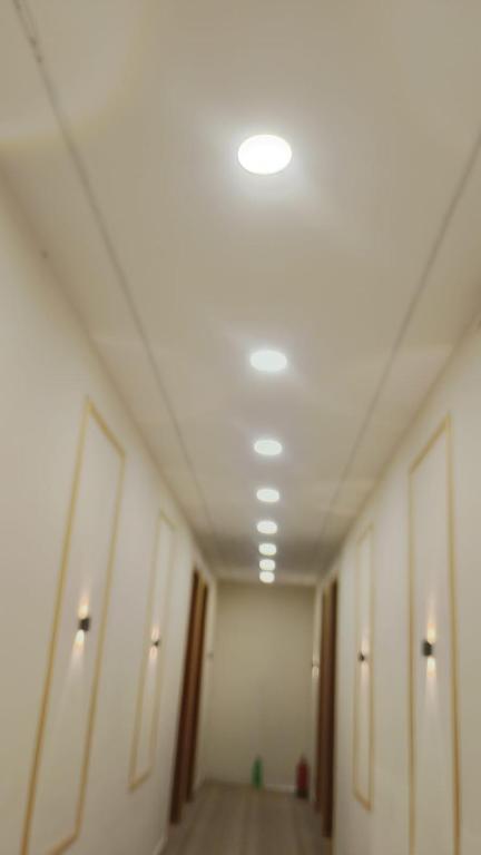 a hallway of an office building with lights on the ceiling at Kanha Hotel in Kānpur