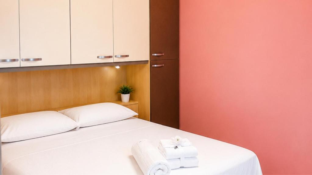ein Schlafzimmer mit einem weißen Bett, auf dem Handtücher liegen in der Unterkunft Dimora Morge in Policoro