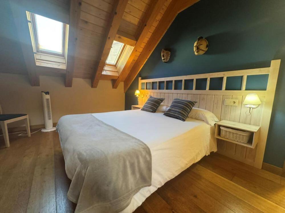 a bedroom with a large white bed with two pillows at Hostal Casa Otsoa in Ezcároz