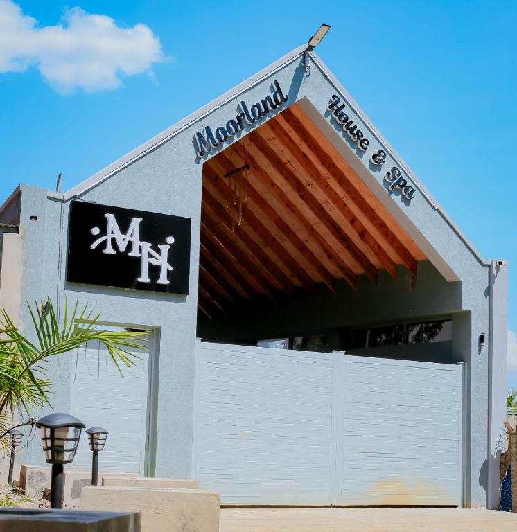 a building with a garage with a sign on it at Moorlandhouse & SPA in Migori