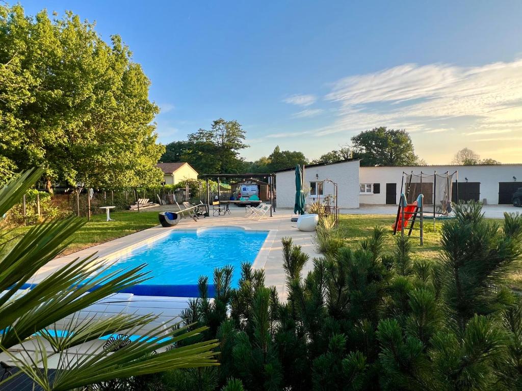 a backyard with a pool and a playground at Chez Laurie et Xavier studio 1 in Mignaloux-Beauvoir