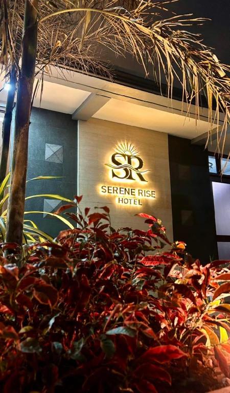 a sign for a service fee hotel with a plant at Serene Rise Hotel Angeles City in Angeles