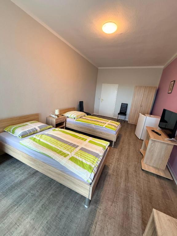 a room with two beds and a television in it at Zimmer für Monteure in Crivitz
