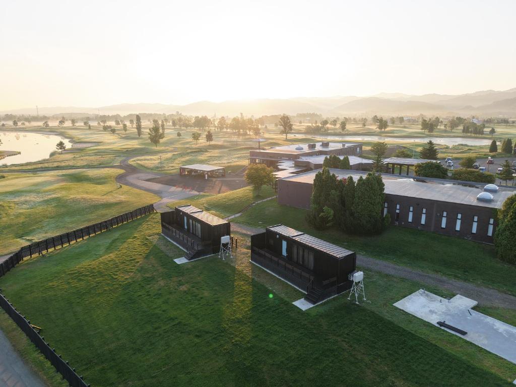 an overhead view of a building with a green field at Hokkaido Zen Cabin in Bibai