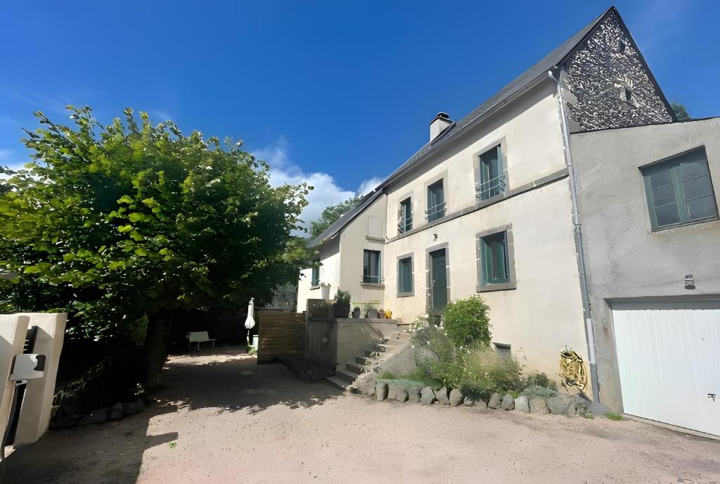 a white building with a gate and a tree at Le Puy D'Eraigne in Saint-Nectaire