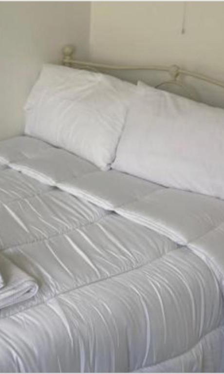 a white bed with white sheets and pillows at Kinsale central 8 in Cork