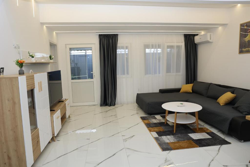 a living room with a black couch and a table at Elegant City Home-Free Parking in Timişoara