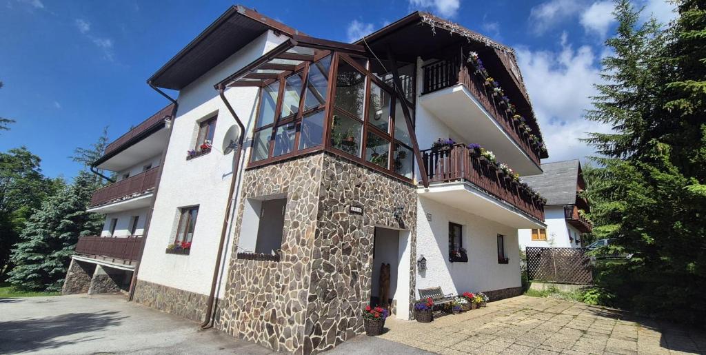 a building with a balcony on the side of it at Penzión Sibír Bed & Breakfast in Starý Smokovec