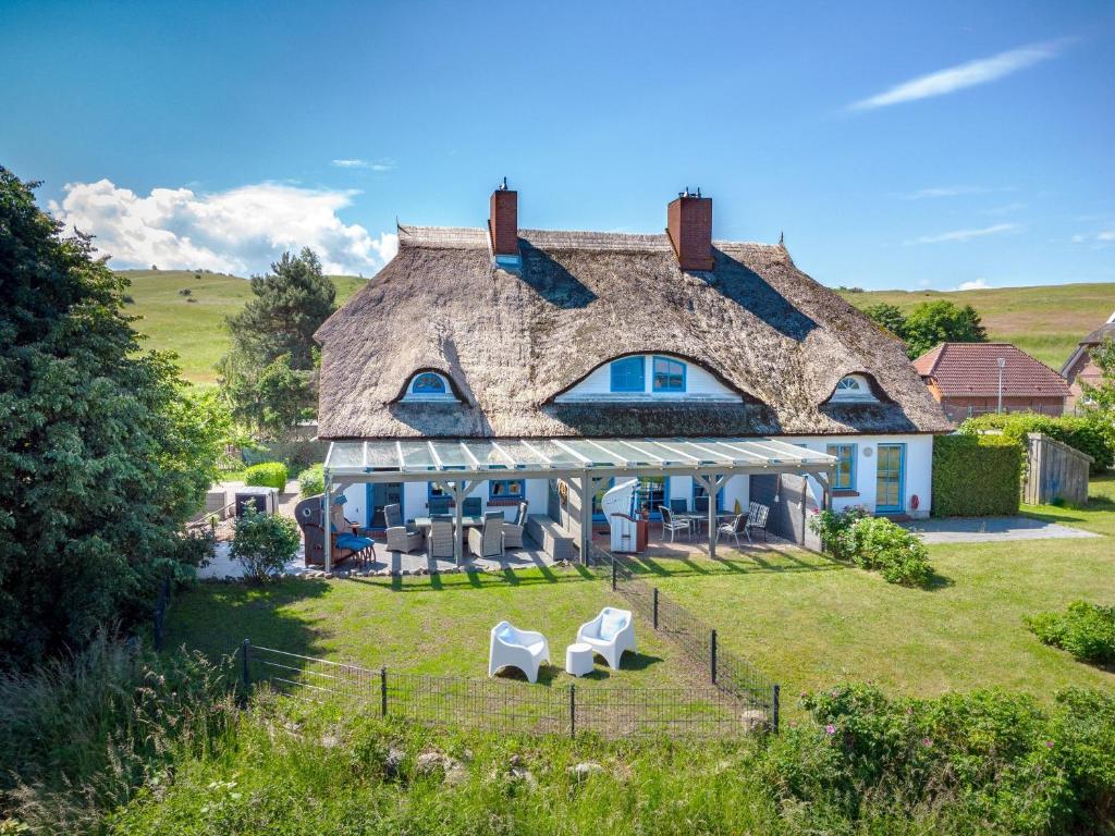 a large house with a thatched roof at Reethaus Zickersche Berge - WG 02 mit Kamin und Terrasse in Gager