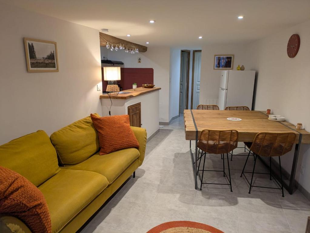 a living room with a yellow couch and a table at La Cachette Floracoise in Florac