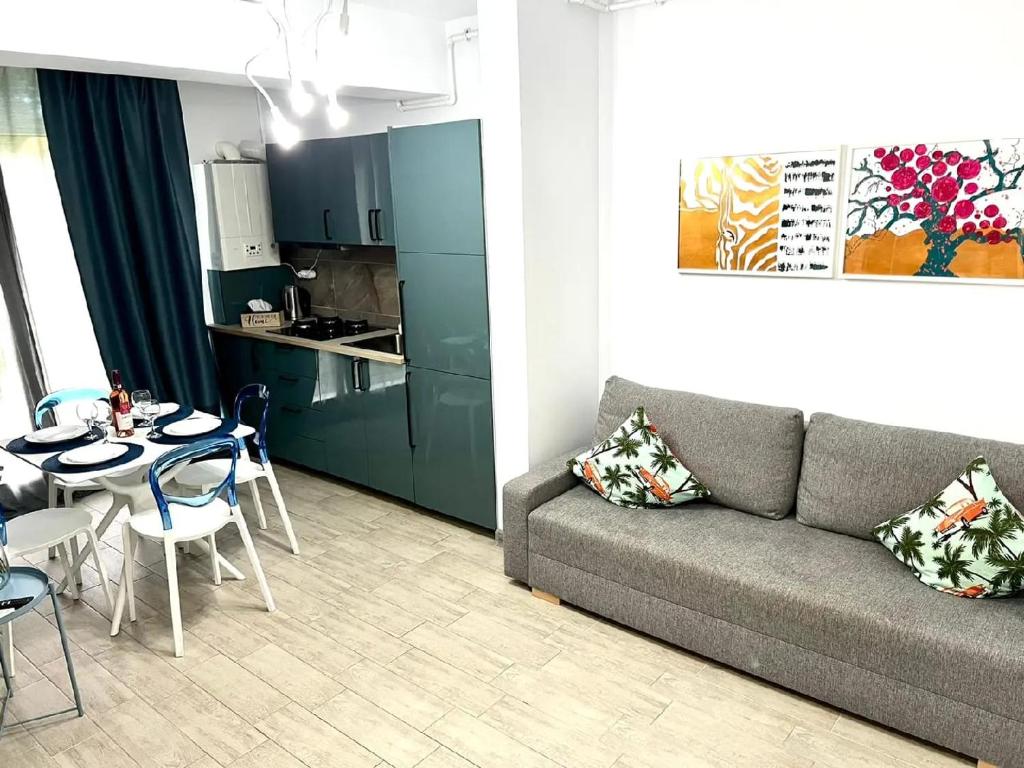 a living room with a couch and a table with chairs at Casa Roxana in Năvodari