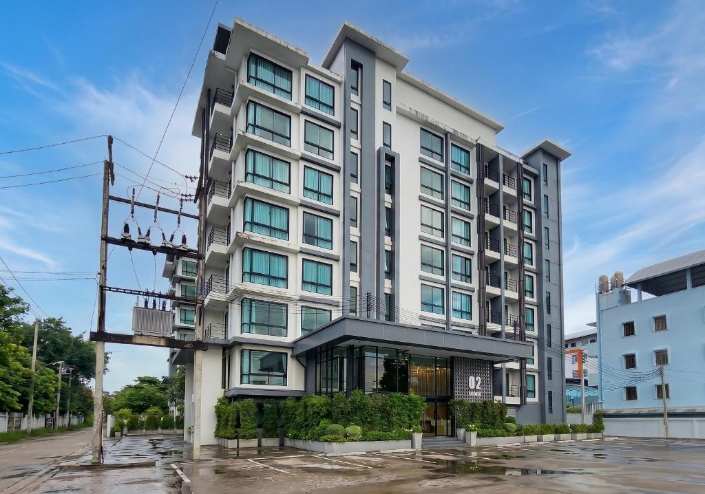 ein hohes, weißes Gebäude mit vielen Fenstern in der Unterkunft O2 Hotel Maesot in Mae Sot