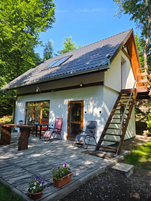 a tiny house with a porch and a deck at Dolina Izerów in Sucha