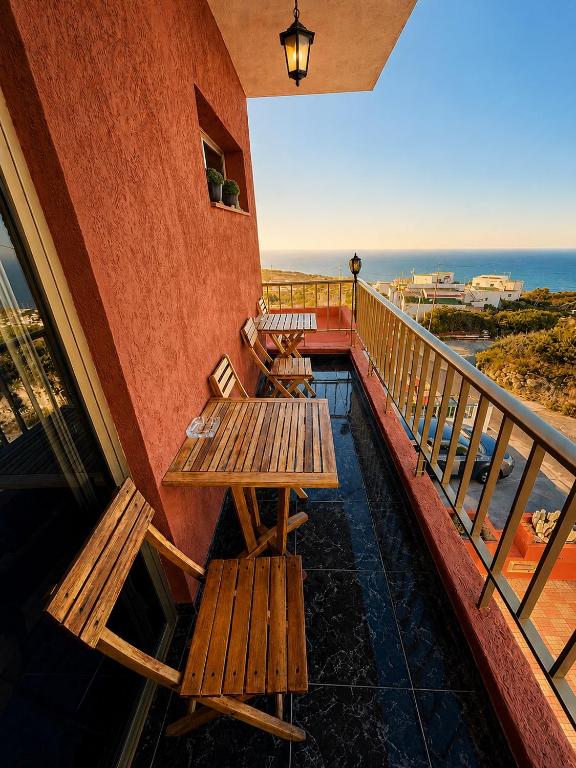 a balcony with wooden benches and a view of the ocean at Naomi’s House in Fasnia
