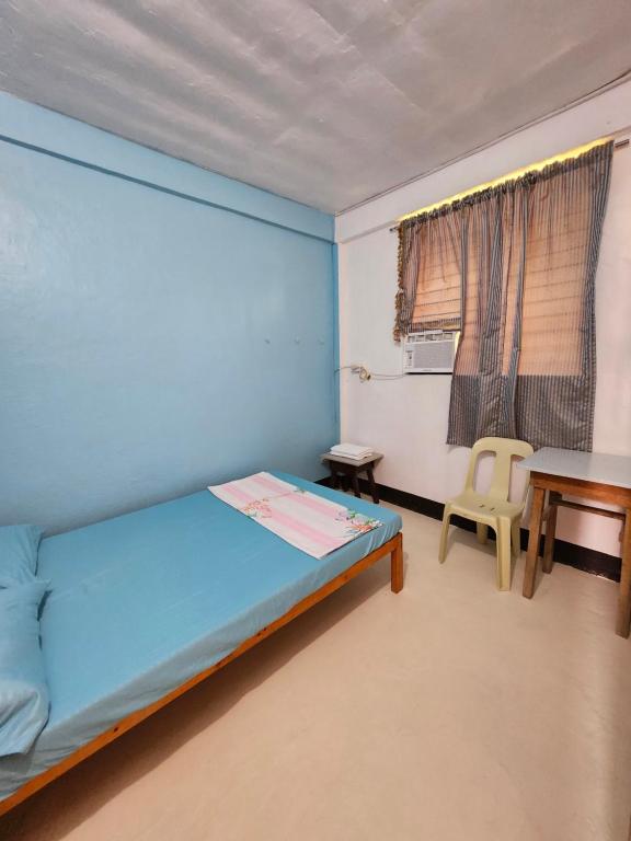 a bedroom with a bed and a table and a window at Aunora Standard Room in San Miguel