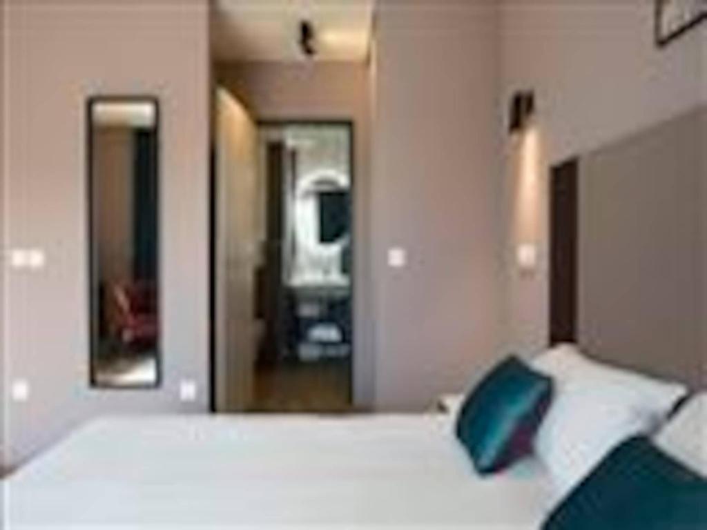 a bedroom with a large white bed with blue pillows at Suite in Premier Thermal Spa Resort in Châtel-Guyon