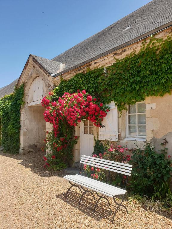 a bench sitting in front of a building with flowers at Studio de Bresteau in Beillé