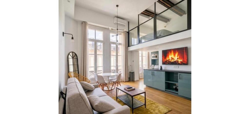 a living room with a couch and a fireplace at Doux Pavillon - Le Loft d'Or in Nice