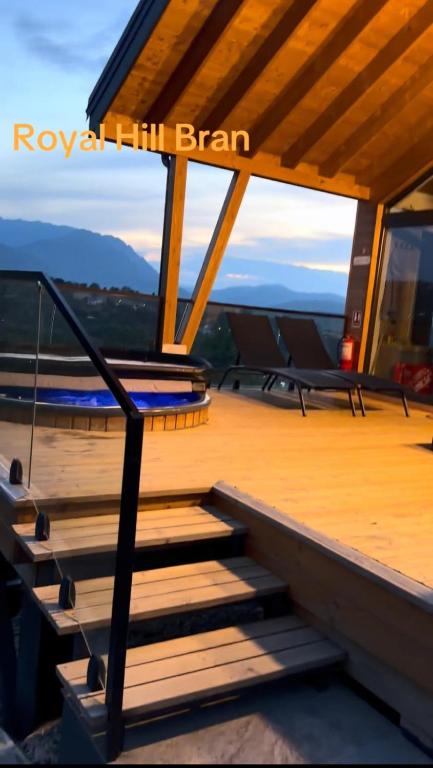 a set of stairs on a roof with mountains in the background at Royal Hill-Queen Chalet -Bran, Mountain View and Hot Tub in Sohodol