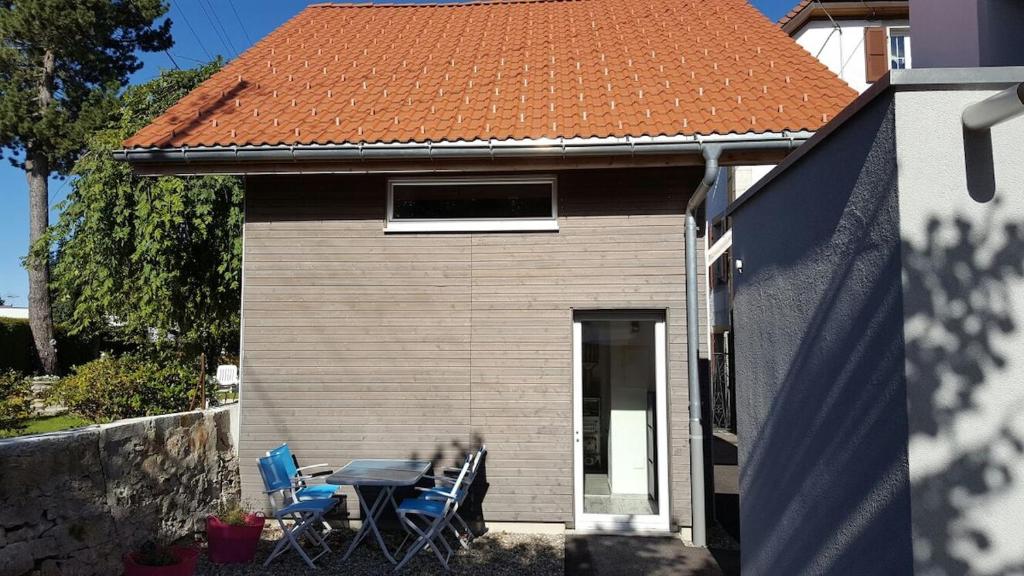 a house with a table and chairs in front of it at Joly Gîte in Les Bois