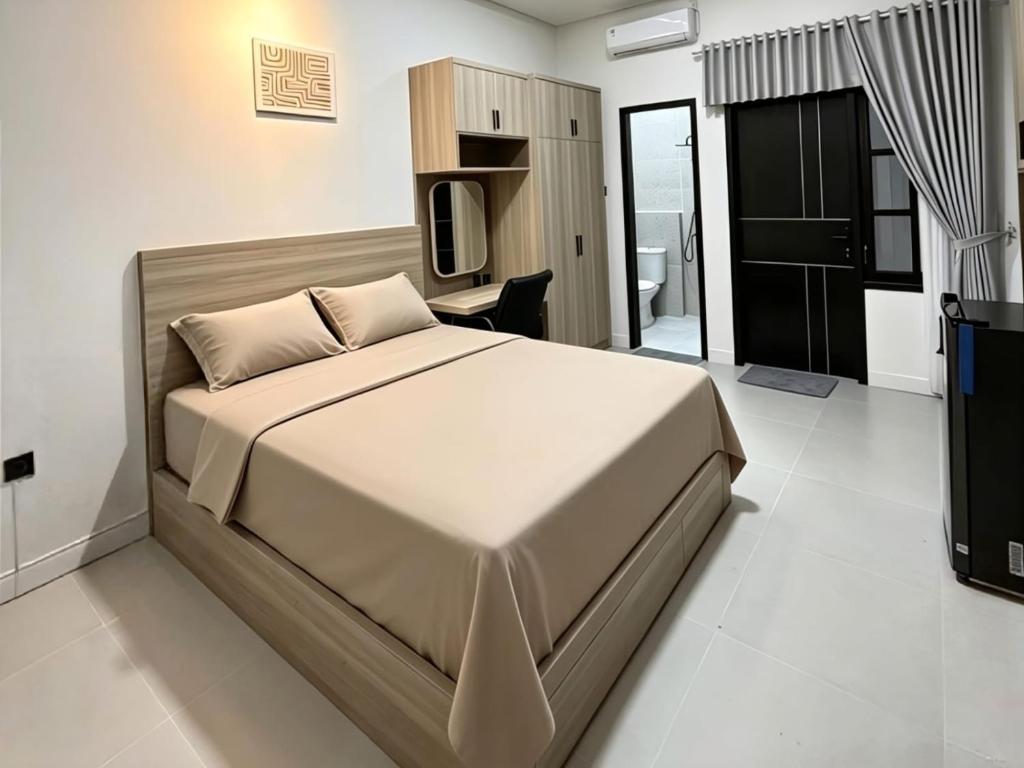 a bedroom with a large bed and a television at D'CIA Coliving in Kejayan
