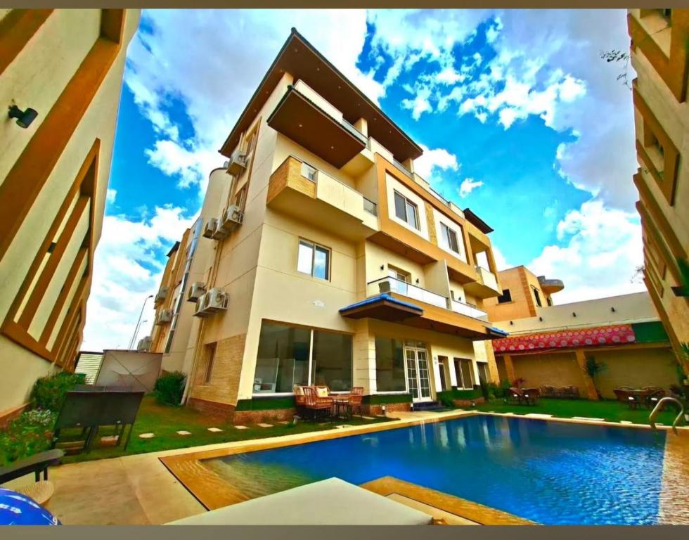 a house with a swimming pool in front of it at My Villa Hotel in Sheikh Zayed
