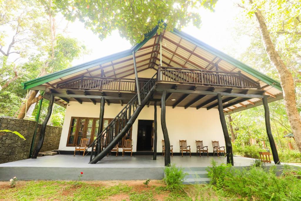 a pavilion with chairs and tables in front of a building at Shena resort in Habarana