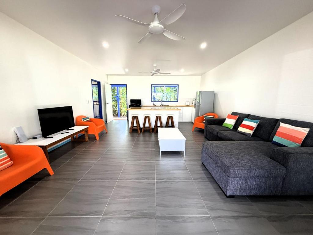 a living room with orange and black furniture and a ceiling at Kuki Kainga in Matavera