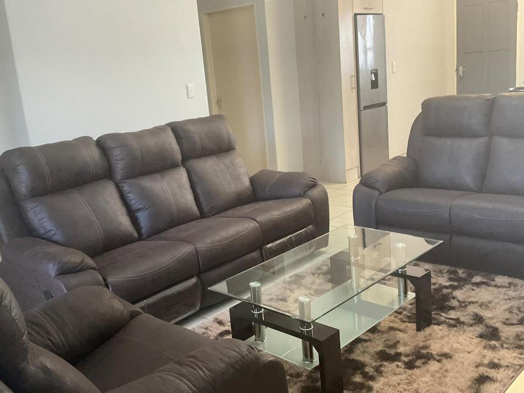 a living room with a leather couch and a coffee table at Katima VVIP in Katima Mulilo