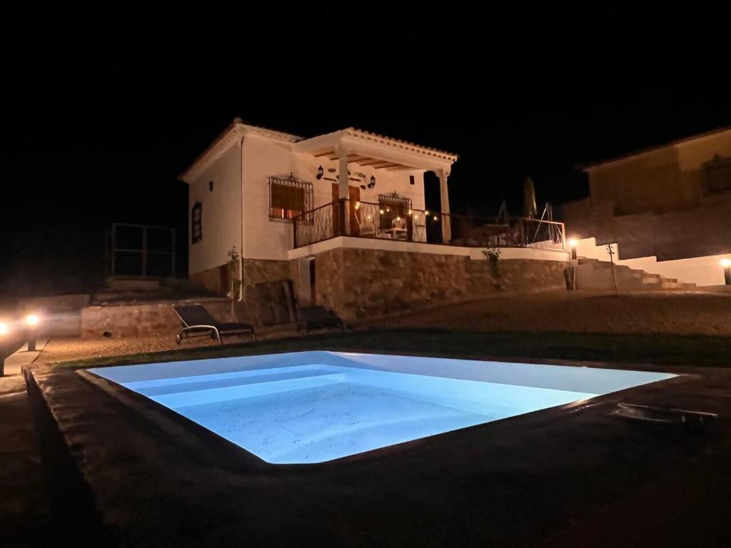 a swimming pool in front of a house at night at Casita La Cometa in Ruidera