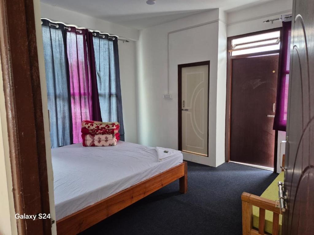 a small bedroom with a bed with a window at Changey Inn-Kolakham in Rishop