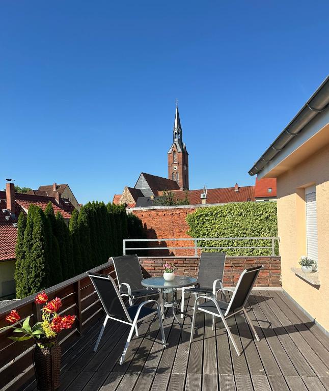 a patio with a table and chairs on a balcony at Ferienwohnung Kirchblick, für Familien, Freunde, keine Monteure in Gräfenhainichen
