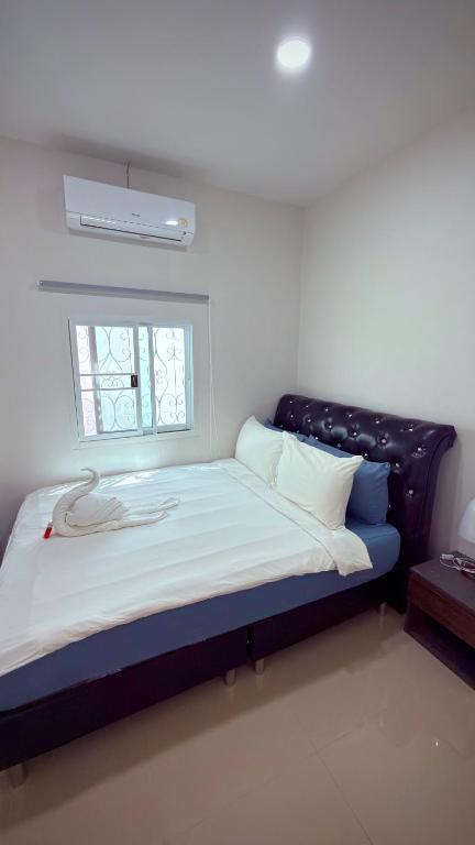 a large bed in a room with a window at The Little House in Chaloklum
