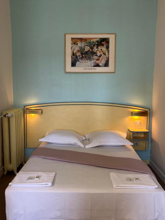 a bedroom with a bed with two towels on it at Le Terminus in Tarascon