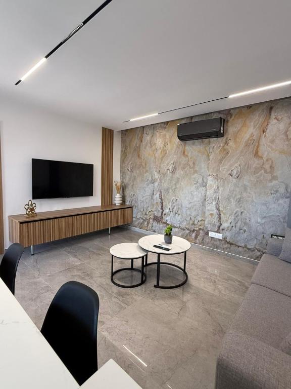 a living room with a couch and a tv at IOLENA Two Bedroom SEAVIEW APT in Pyla