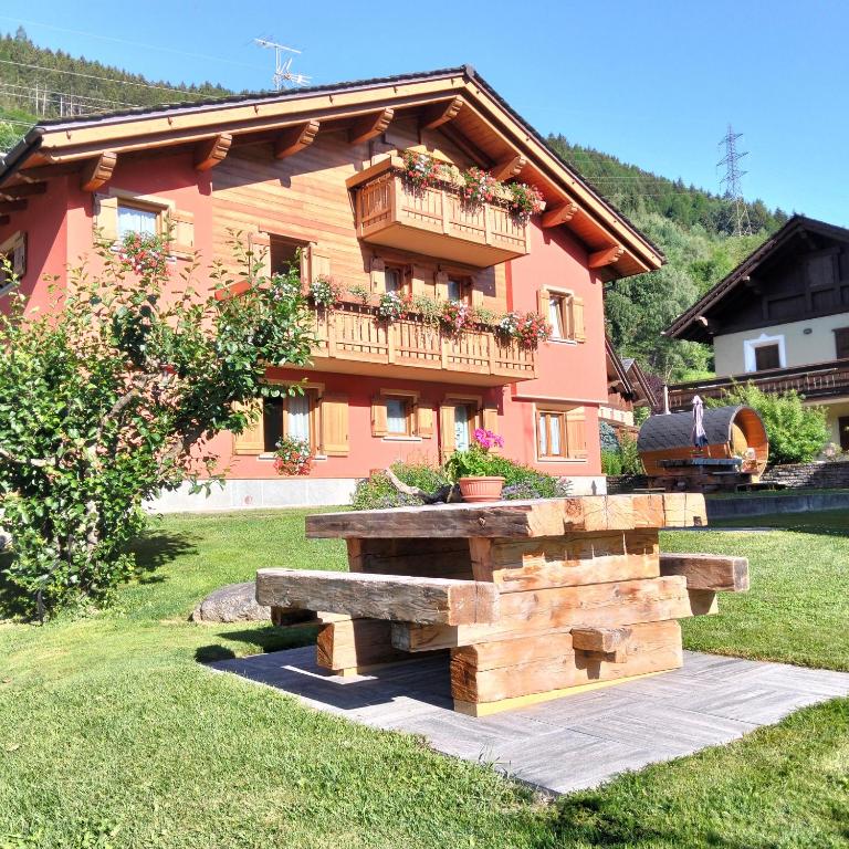 a house with a bench in front of it at Casa Clus Bormio apartments 1 in Valdisotto