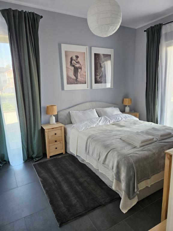 a bedroom with a large bed with green curtains at Wypoczynek nad morzem Uzdrowiskowa 115 in Przewłoka