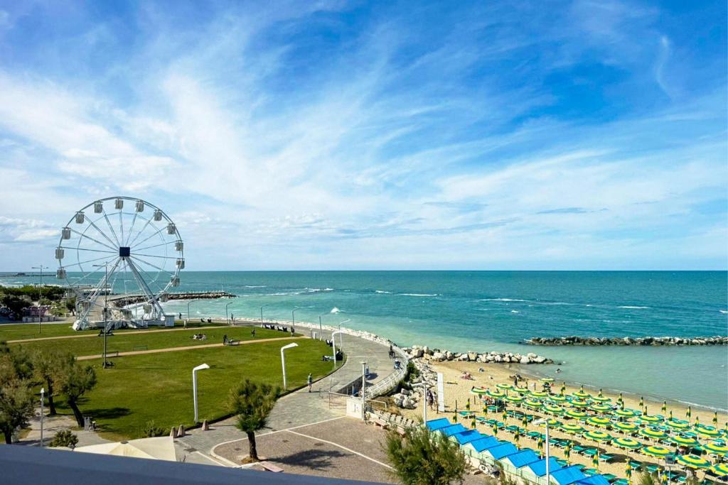 a beach with a ferris wheel and the ocean at B&B HOTEL Pesaro Des Bains in Pesaro