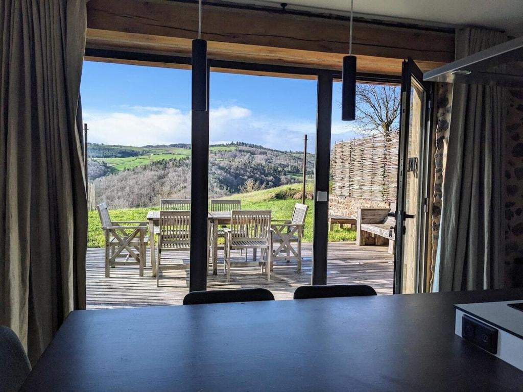 a room with a table and a view of a patio at Grange rénovée - Calme et Vue sur les volcans in Saint-Just-près-Brioude