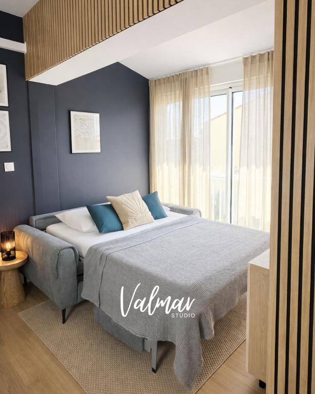 a bedroom with a large bed with blue walls at Studio Valmar, accès plage 150m in Valras-Plage