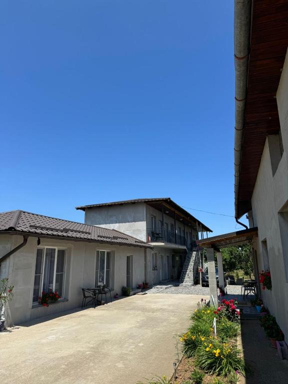 a large building with a porch and a driveway at Casa Osan in Tăşnad
