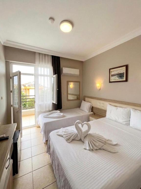 a hotel room with two beds and a window at jasmine otel in Kemer