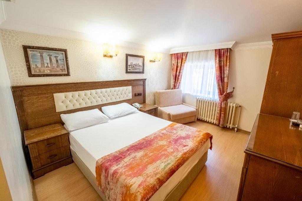 a hotel room with a bed and a chair at Assos Kervansaray Hotel - Special Category in Behramkale